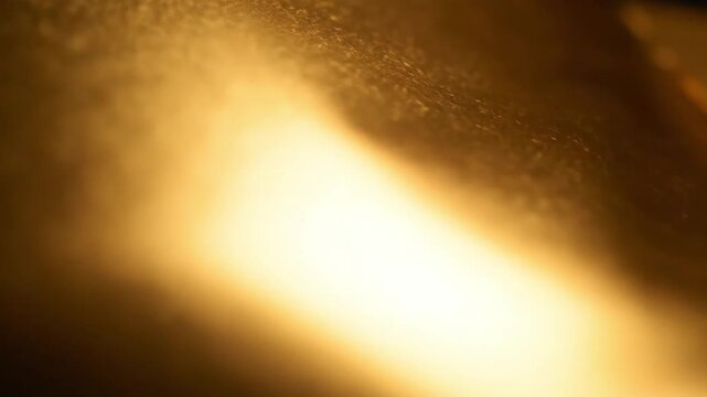 Luxury gold foil texture with shimmering warm light reflections for premium cosmetic packaging