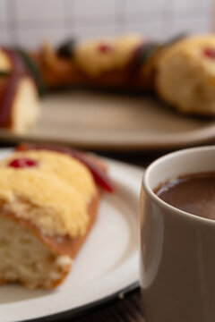 Cup hot chocolate, a slice of "Rosca de Reyes" or epiphany bread in the background.