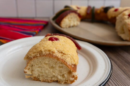 Approach to a slice of "Rosca de Reyes" or Epiphany bread, in the background you can see the complete bread