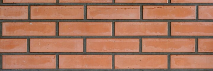 Fototapeta premium Textured surface of an old red brick wall with gray mortar joints background