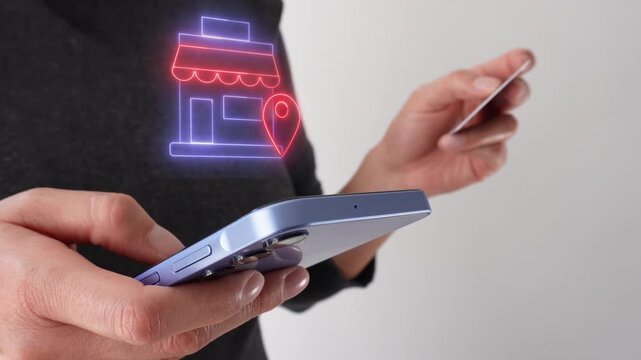 The hands manipulate a smartphone with a holographic icon that simulates the location of a store.