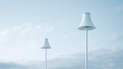 Obraz premium Minimalist white lamp posts standing tall against a pale blue sky with subtle clouds