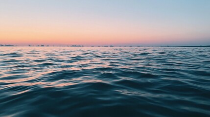 Fototapeta premium Tranquil Ocean Horizon at Sunset with Gentle Waves and Soft Sky Colors