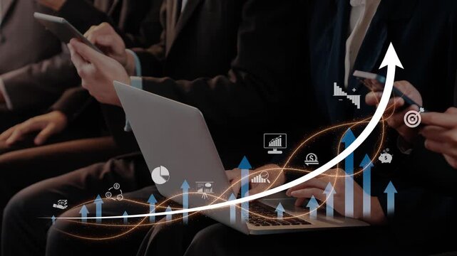 A group of business professionals focus on data analysis during a conference. Laptops and tablets display growth charts and statistical data, symbolizing success. Raster