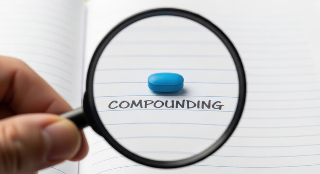 Pharmaceutical compounding concept with blue pill and magnifying glass focusing on handwritten word for research and development in pharmacy
