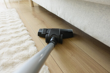 Cleaning under furniture with a vacuum cleaner