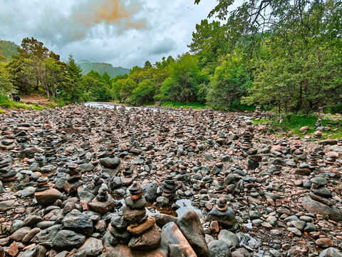 Rocky riverbed surrounded by green forest and mountains