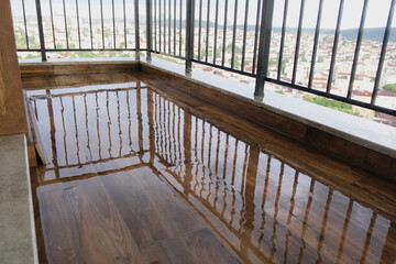 Fototapeta premium Water pooled on wooden floor in balcony area