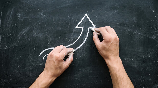 Hands writing math equations on chalkboard