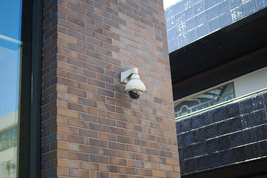 Security camera on a brick wall in an urban area