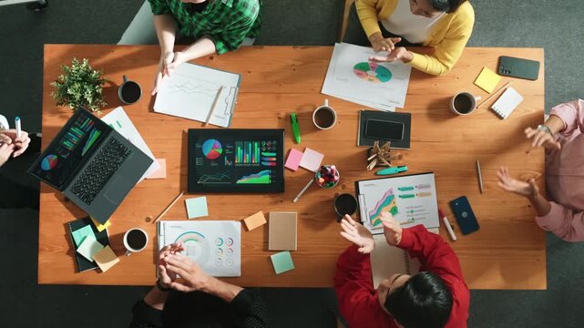 Top view of business team clapping hand and shaking hands together for celebrate successful corporate deal. Top down aerial view of business man present start up project at whiteboard. Convocation.