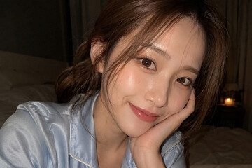 Fototapeta premium 夜の寝室で頬杖をつく青いパジャマ姿の女性