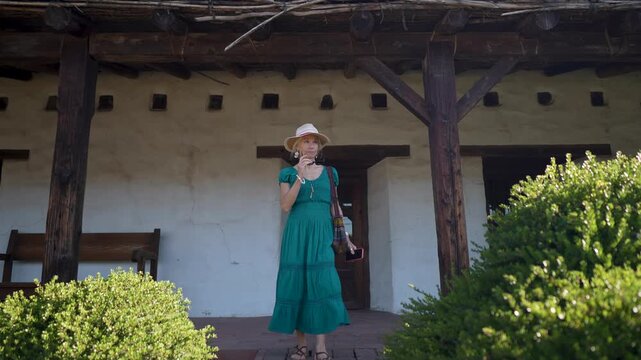 Happy senior woman walks around historic Mission church San Francisco Solano de Sonoma in Sonoma California exploring the site