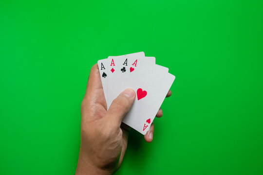 male hand hold four aces playing cards on green casino table. gambling concept