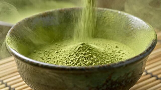 Pouring green matcha powder into a rustic ceramic bowl.