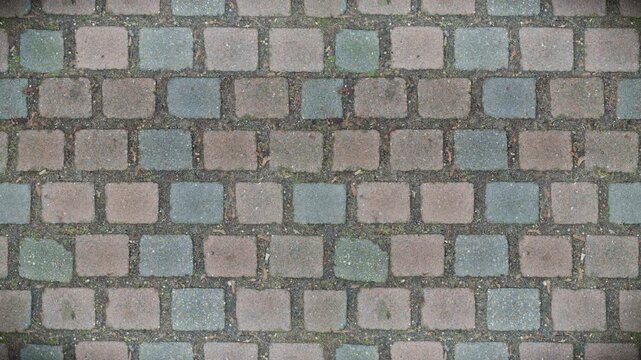 Weathered paving stones form a rustic seamless loop background pattern.
