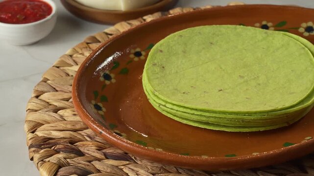 Authentic Mexican breakfast ingredients featuring green tortillas fresh, cheese wheel and spicy red sauce