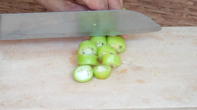 Slicing Chili Peppers on a Wooden Cutting Board