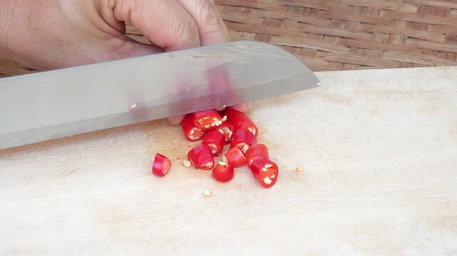 Slicing Chili Peppers on a Wooden Cutting Board