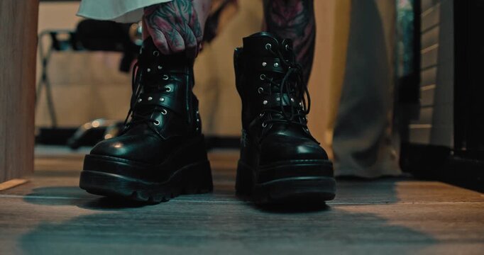 Young Woman Lacing Up Chunky Black Platform Combat Boots