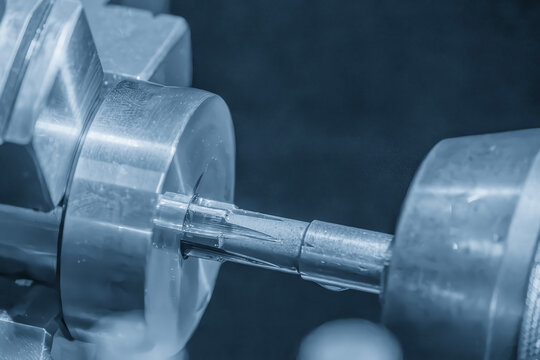 Metal lathe machine performing hole finishing process using reamer tool in light blue lighting