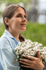 Spring flowers bouquet held by young woman enjoying sunny garden day with Bellis perennis daisies © svetograph