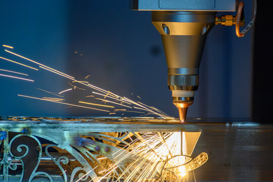 Sparks flying from fiber laser cutting machine cutting steel square tube part
