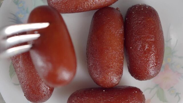 Gulab Jamun Dessert on Plate With Fork. Indian Sweet Syrup Treats Close-Up