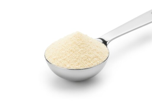 Close-up of a measuring spoon filled with white powder, isolated on a clean white background.