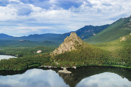 Panoramic view of Burabay Borovoe Lake and beautiful mountain Okzhetpes and rocky island Zhumbaktas, cloud blue sky. Burabay National Nature Park in Republic of Kazakhstan. Summer scenery landscape.