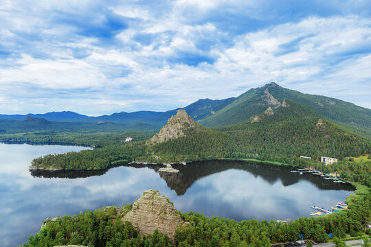 Panoramic view of Burabay Borovoe Lake and beautiful mountain Okzhetpes and rocky island Zhumbaktas, cloud blue sky. Burabay National Nature Park in Republic of Kazakhstan. Summer scenery landscape.