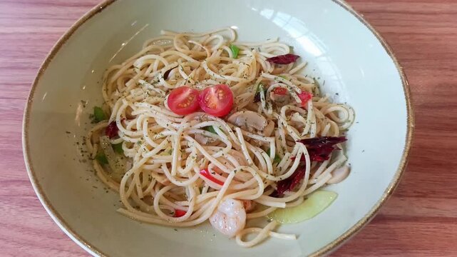 Spaghetti aglio olio pasta with cherry tomatoes in bowl
