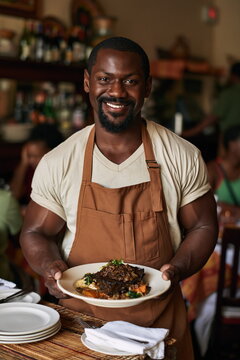 Sophisticated Waiter Presenting Exquisite Gourmet Dish with Artistic Plating in Upscale Restaurant, Creating an Atmosphere of Culinary Delight