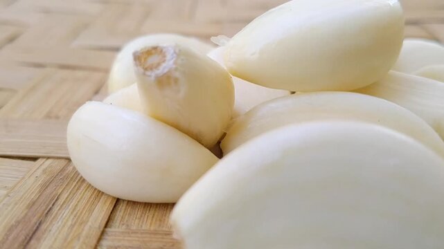 Studio shot of raw peeled garlic cloves isolated on a solid white background