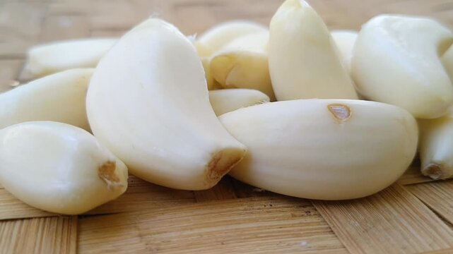 Macro shot of fresh peeled garlic cloves highlighting individual segments and natural oils