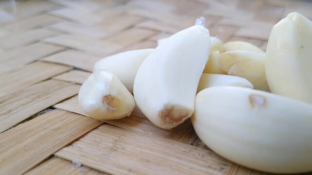 Fresh peeled garlic cloves isolated on a pure white background for culinary and food design projects