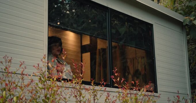 Young Tattooed Woman Stretching on the Balcony of a Wooden Cabin in the Morning