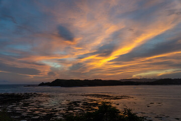Fototapeta premium Colorful sunset sky over coastal landscape and calm sea