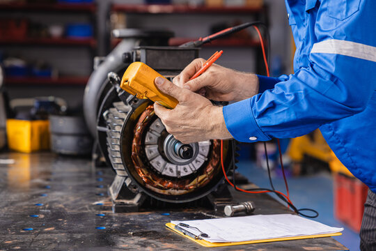 Electrical Maintenance Motor. Technician at Work measuring power meter with Electric motor in modern heavy EV car industry