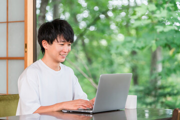Fototapeta premium A young man who is a work hopper and does remote work.