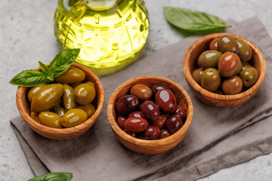 An assortment of various olives presented in a bowl, showcasing different colors, textures