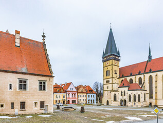 Obraz premium The Basilica of St Giles and historic town square under a cloudy sky in winter at the UNESCO World Heritage Site.