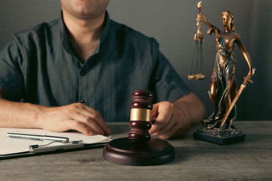 lawyer working with documents and wooden gavel on table in office
