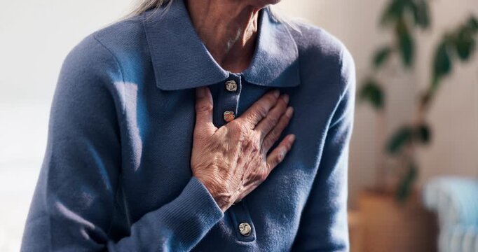 Chest pain, bed and hand of elderly woman in home with discomfort, heartburn or asthma symptoms. Hypertension, medical emergency and senior female person with cardiac arrest in bedroom of house