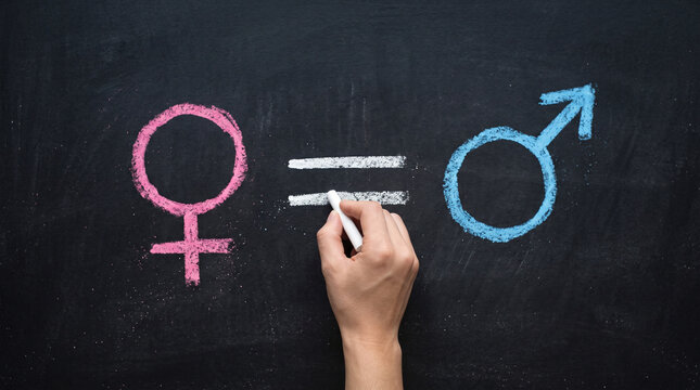 Hand drawing gender equality symbols on chalkboard. Male and female signs. Concept of equal rights.