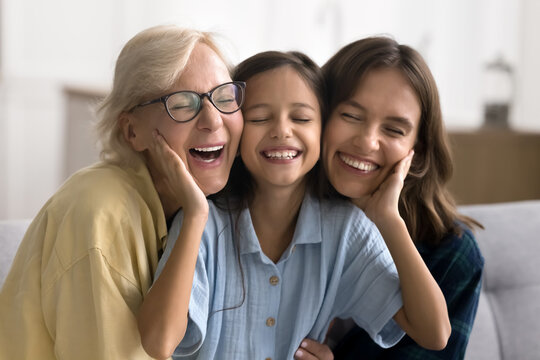 Lovely preteen girl enjoy moment of tenderness and warmth with loving older grandma and young pretty mom seated on sofa at home. Multigenerational family bonding, attachment and harmonic relationships
