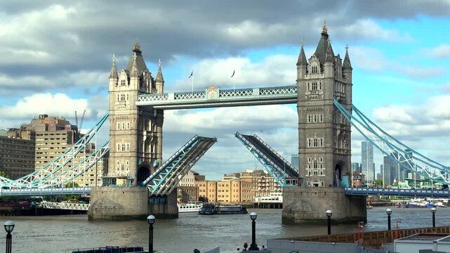 A historic bascule bridge lifts its towers open to allow a vessel through beneath dramatic clouds