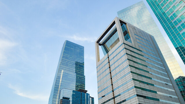 Contemporary glass and steel skyscrapers dominating the urban skyline against a blue sky
