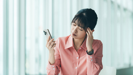 スマートフォンを見て困るビジネスウーマン, Businesswoman Looking Worried at Her Smartphone © Trickster*
