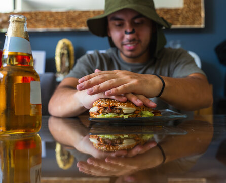 Man preparing to eat his beef burger and beer